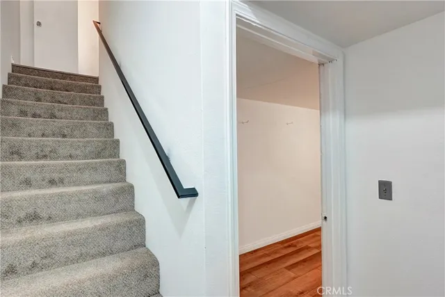 a view of staircase with white walls and white door