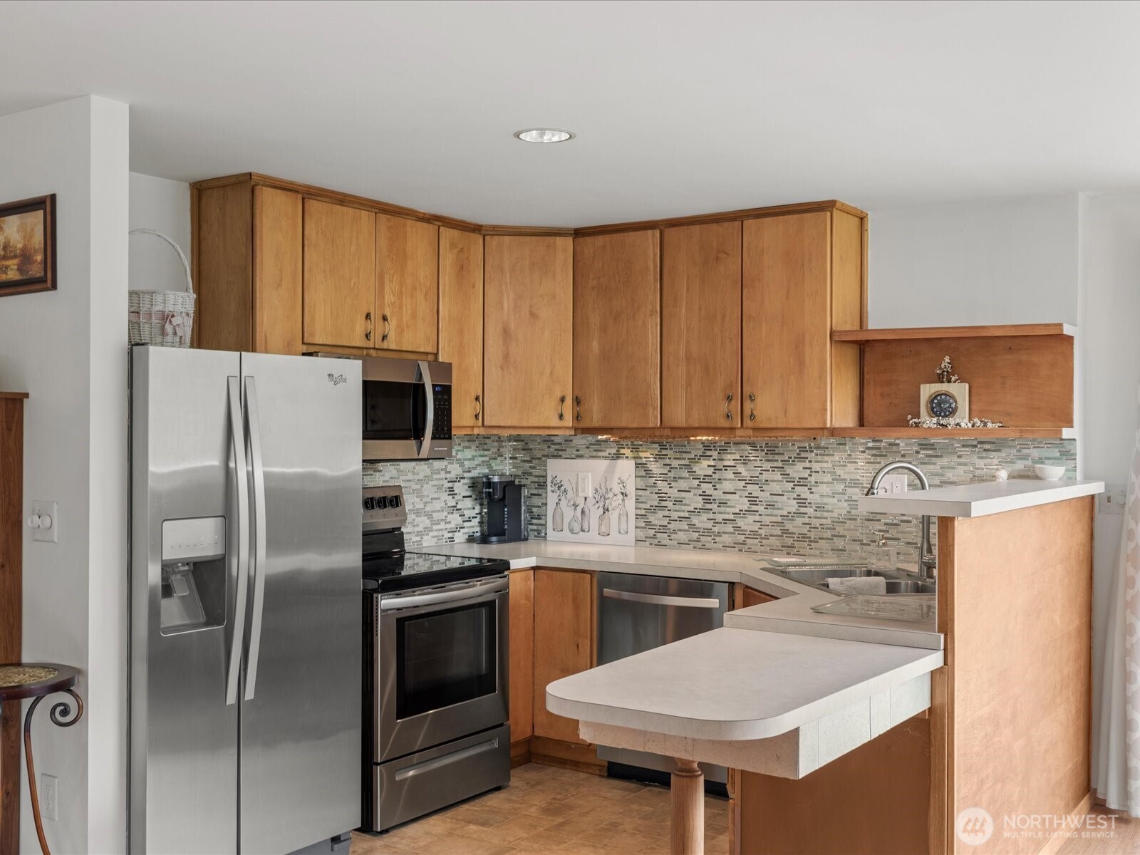 1401 Southwest 137th Street Burien, WA 98166 - Photo 29 of 40 a kitchen with stainless steel appliances a sink a stove a refrigerator cabinets and a counter top space