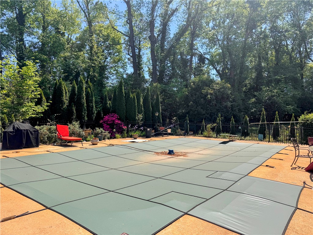 208 Knoxwood Court Anderson, SC 29621 - Photo 33 of 38 This serene backyard features a private pool with a safety cover, nestled amongst lush greenery.