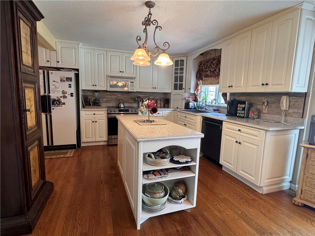 208 Knoxwood Court Anderson, SC 29621 - Photo 7 of 38 An inviting kitchen features a central island, warm wood floors, and abundant white cabinetry.