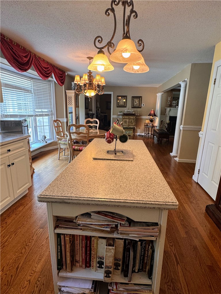 208 Knoxwood Court Anderson, SC 29621 - Photo 9 of 38 This kitchen showcases a functional island with built-in shelving, complemented by rich hardwood flooring.