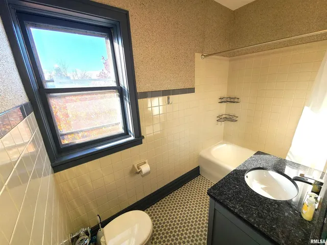 a bathroom with a granite countertop sink toilet and a mirror
