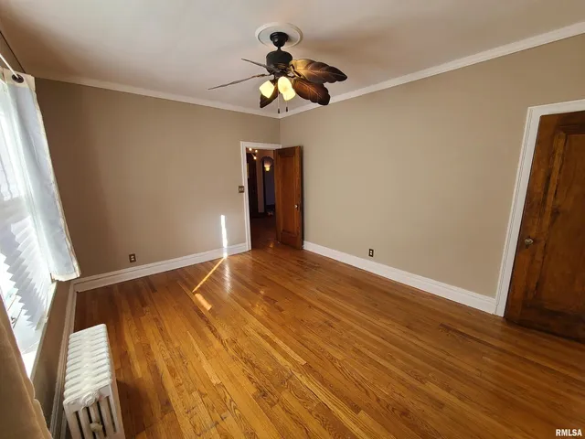 a view of empty room with wooden floor