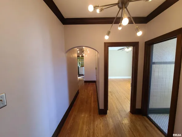 a view of a hallway with wooden floor and staircase