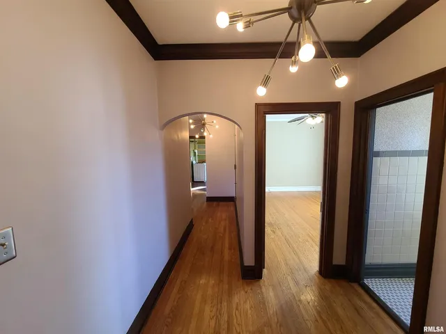 a view of a hallway with wooden floor and staircase