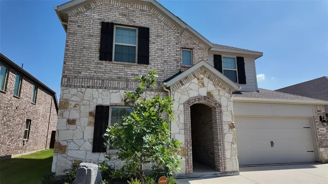 a front view of a house with plants