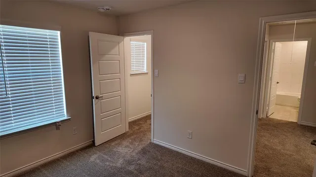 an empty room with windows and cabinet