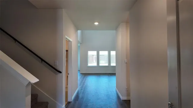 a view of hallway with wooden floor and stairs