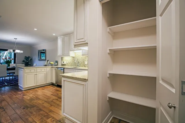 a kitchen with white cabinets and counter space