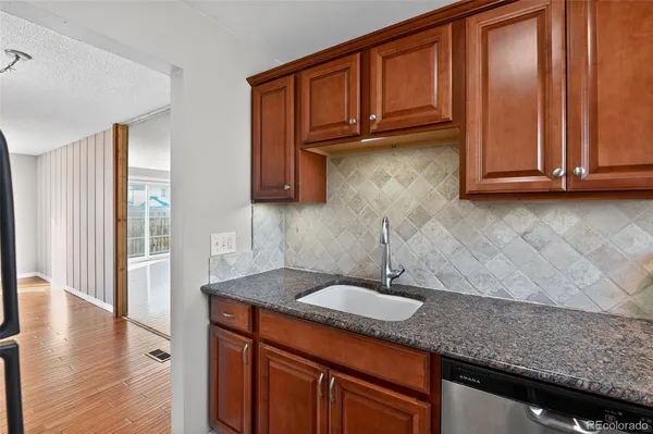 a kitchen with granite countertop stainless steel appliances a sink and cabinets