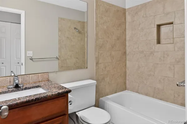 a bathroom with a granite countertop sink toilet and shower