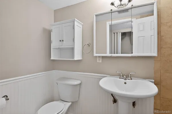a bathroom with a toilet sink and mirror