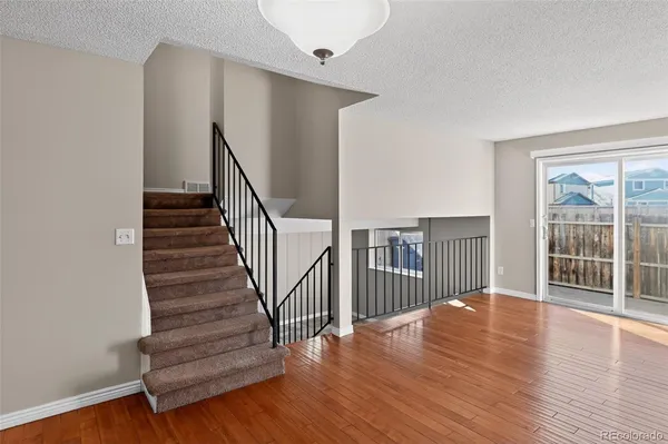 a view of a hallway with wooden floor and stairs