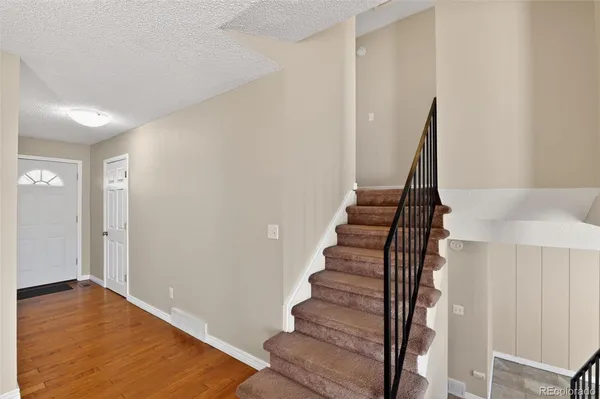 a view of staircase with wooden floor and white walls