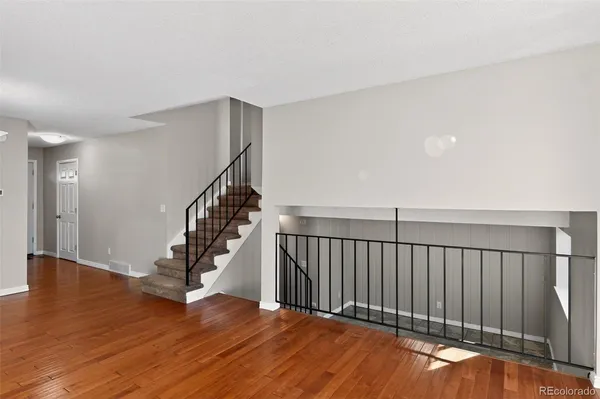 a view of a hallway with wooden floor and entryway