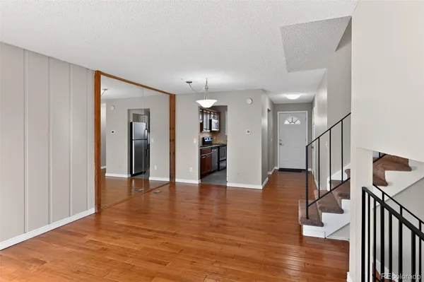 a view of a hallway with wooden floor and staircase