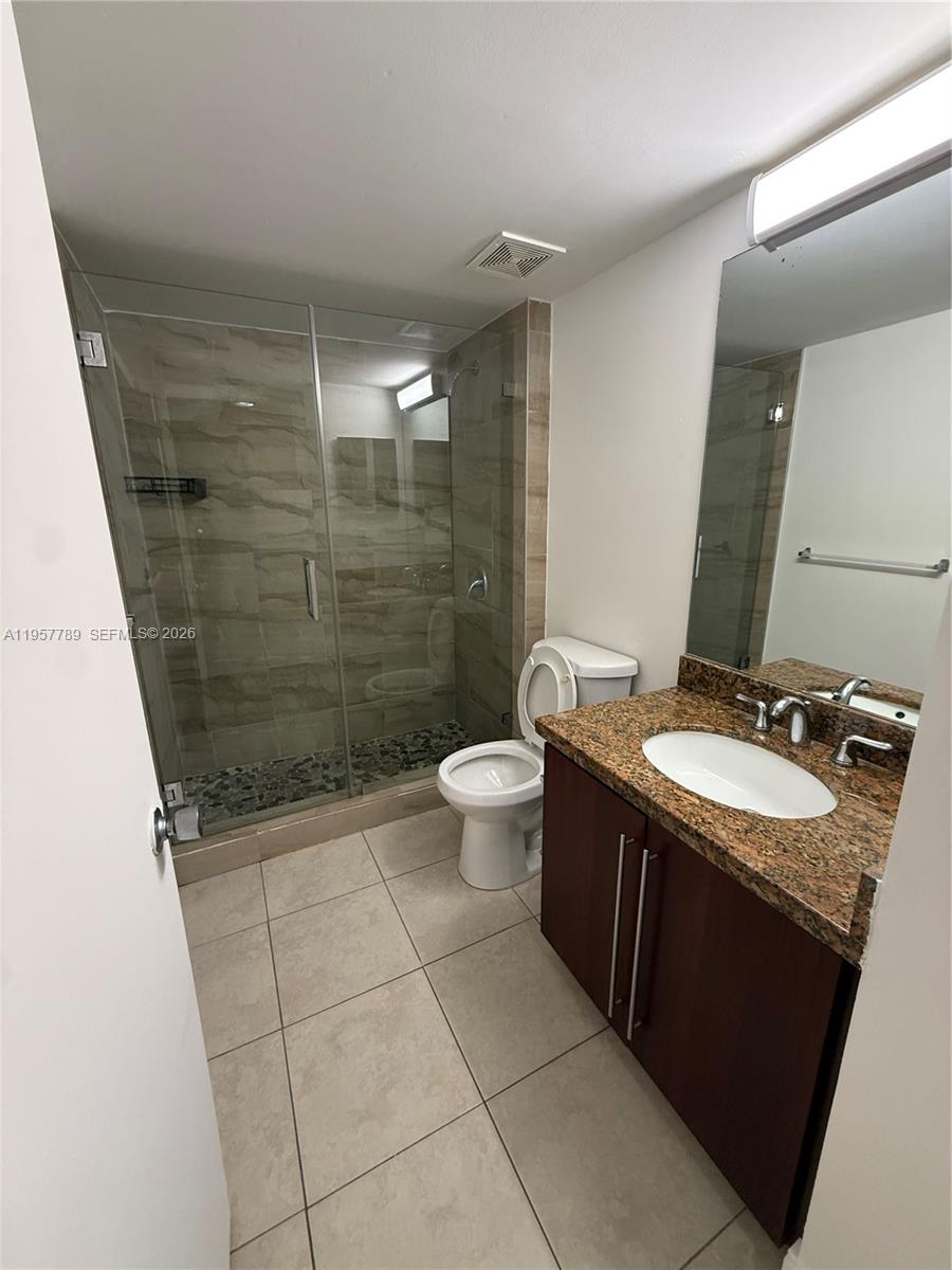 761 North Pine Island Road, Unit 104 Plantation, FL 33324 - Photo 20 of 26 a bathroom with a granite countertop sink a toilet a mirror and shower