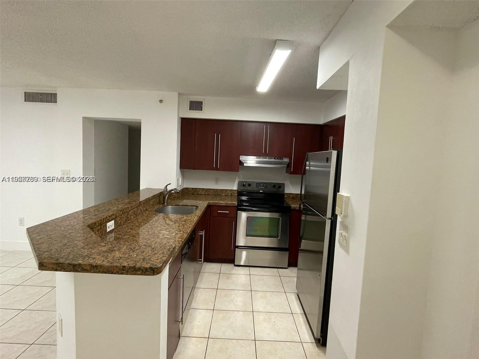761 North Pine Island Road, Unit 104 Plantation, FL 33324 - Photo 2 of 15 a kitchen with granite countertop a sink a stove and refrigerator