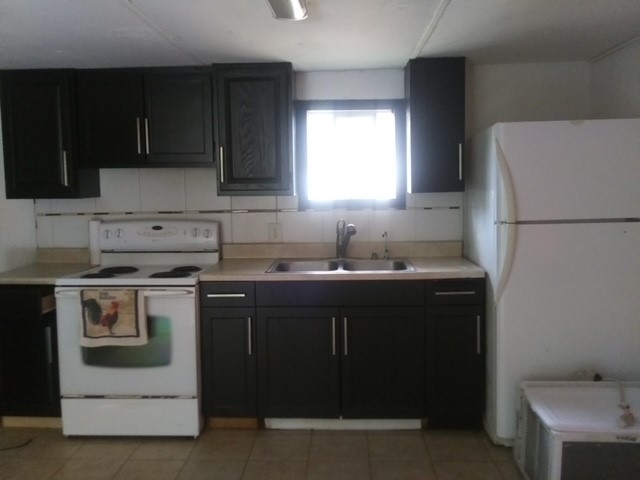 2264 County Road 3405 Cleveland, TX 77327 - Photo 5 of 10 a kitchen with a sink a stove and refrigerator