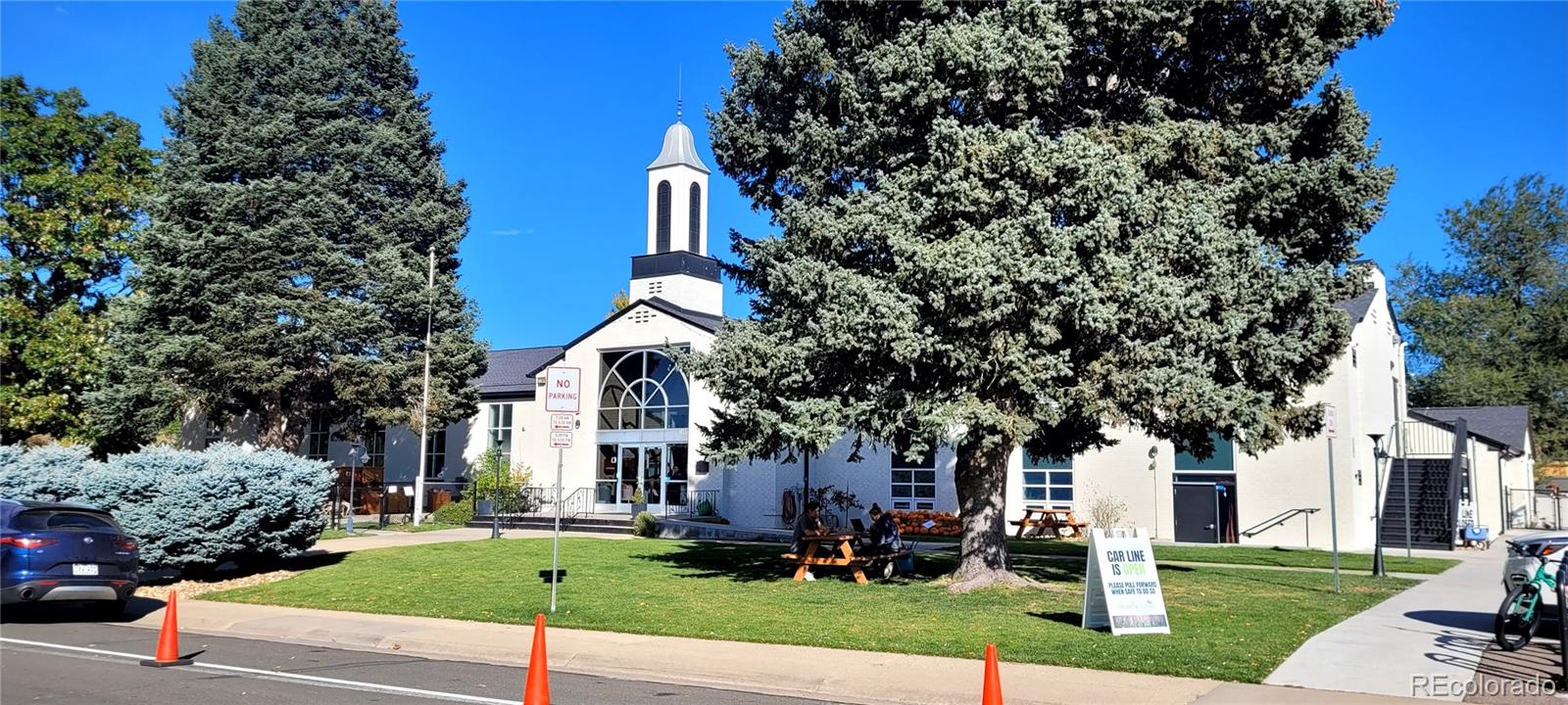 3450 Benton Street Wheat Ridge, CO 80212 - Photo 19 of 20 a view of a white house next to a yard with big trees