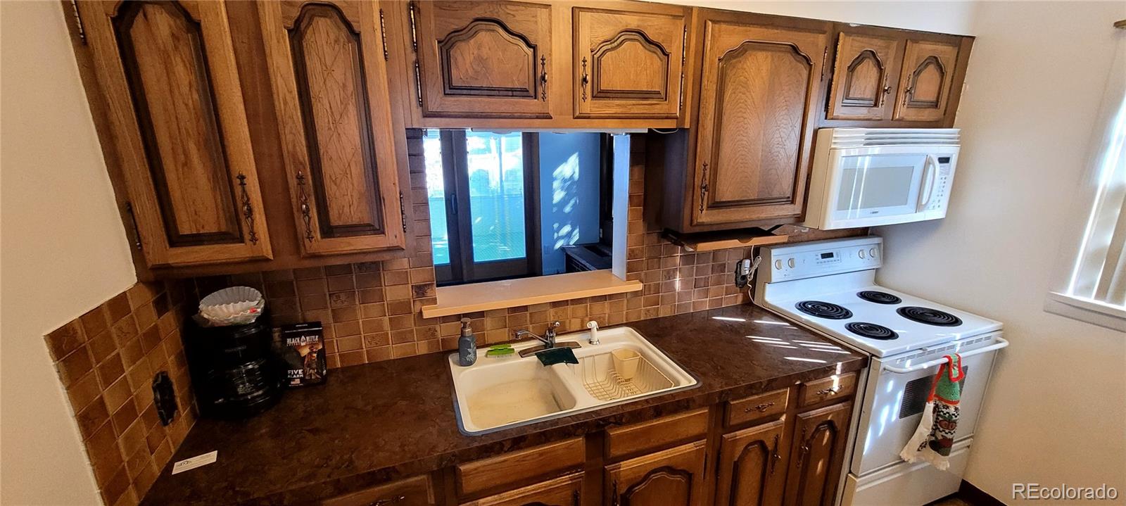 3450 Benton Street Wheat Ridge, CO 80212 - Photo 5 of 20 a kitchen with stainless steel appliances a sink a stove and a microwave