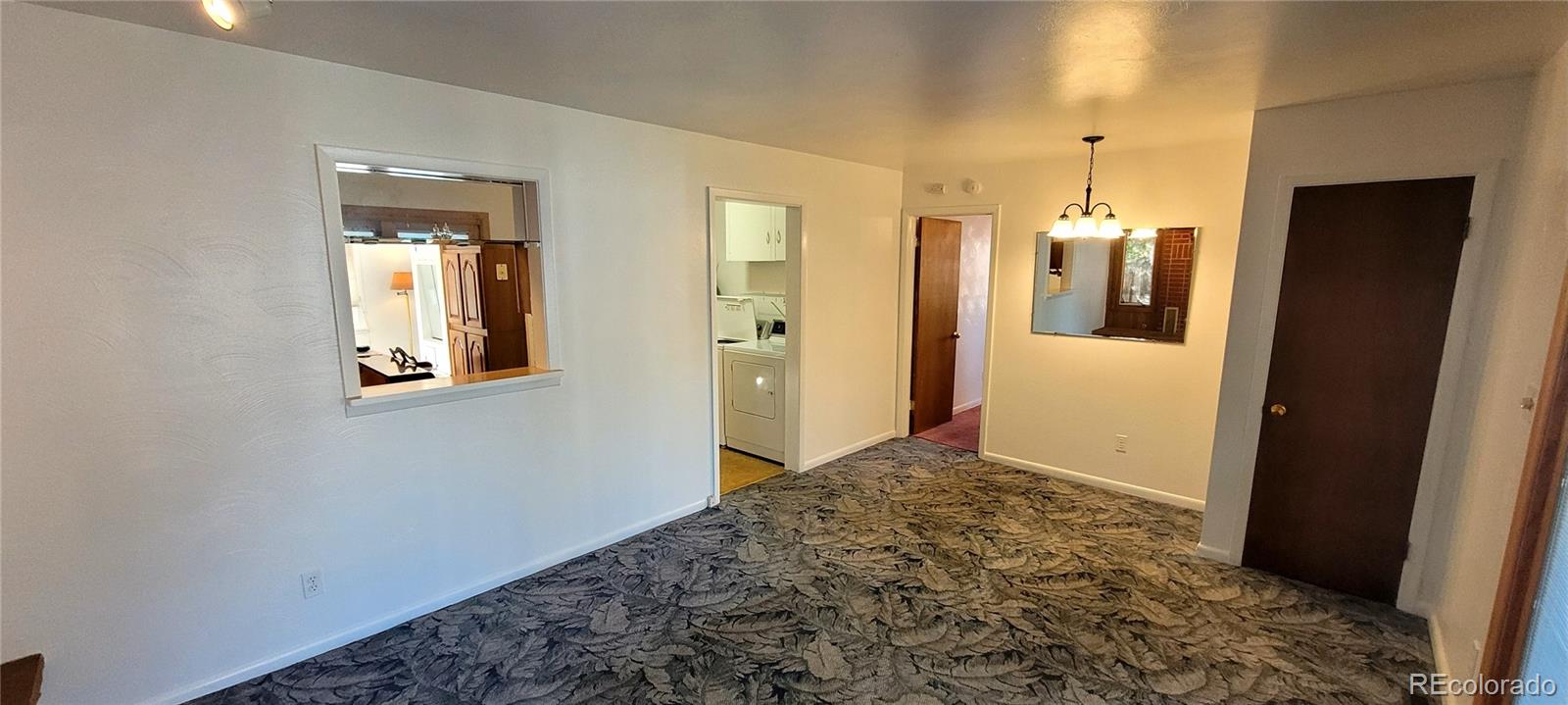 3450 Benton Street Wheat Ridge, CO 80212 - Photo 9 of 20 a view of a hallway with wooden cabinet and mirror