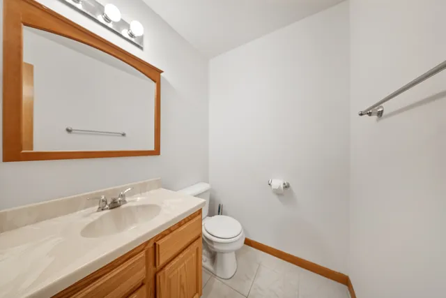 a bathroom with a granite countertop sink a toilet and a mirror