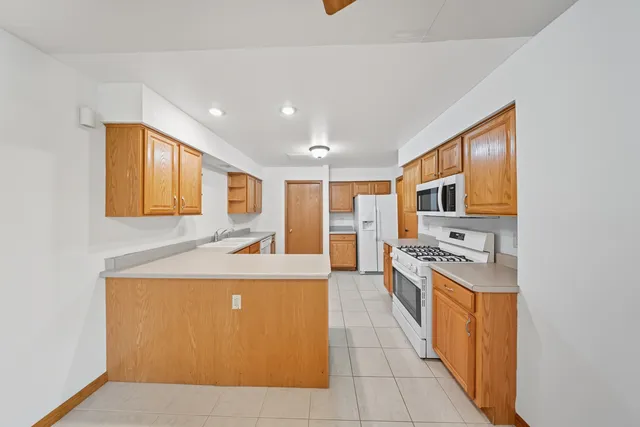 a large kitchen with stainless steel appliances granite countertop a sink and cabinets