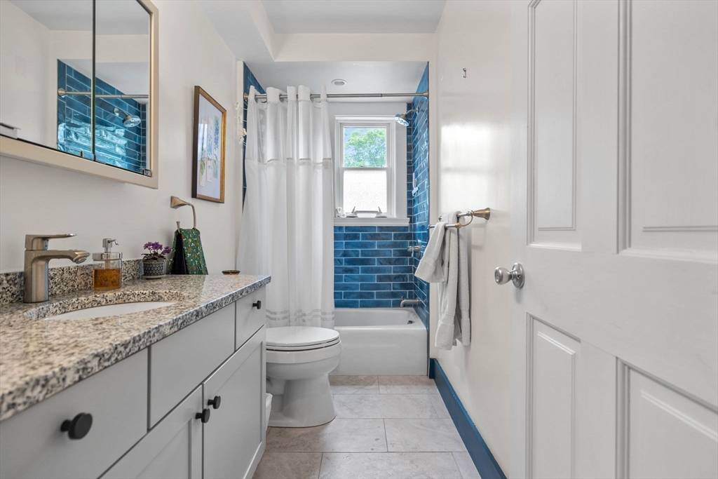 228 Langley Road Newton, MA 02459 - Photo 19 of 39 a spacious bathroom with a granite countertop sink toilet and shower