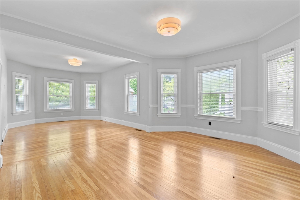 228 Langley Road Newton, MA 02459 - Photo 2 of 39 an empty room with wooden floor and windows