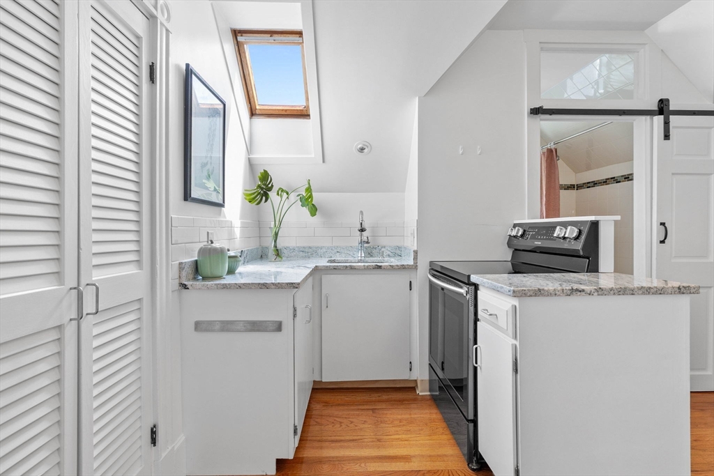 228 Langley Road Newton, MA 02459 - Photo 25 of 39 a bathroom with a sink and a mirror