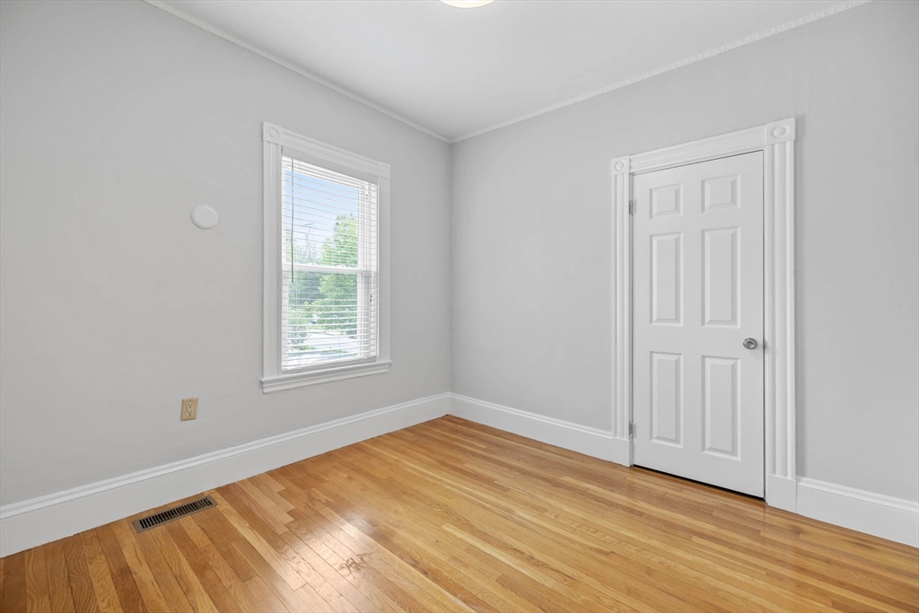 228 Langley Road Newton, MA 02459 - Photo 6 of 39 a view of an empty room with wooden floor and a window