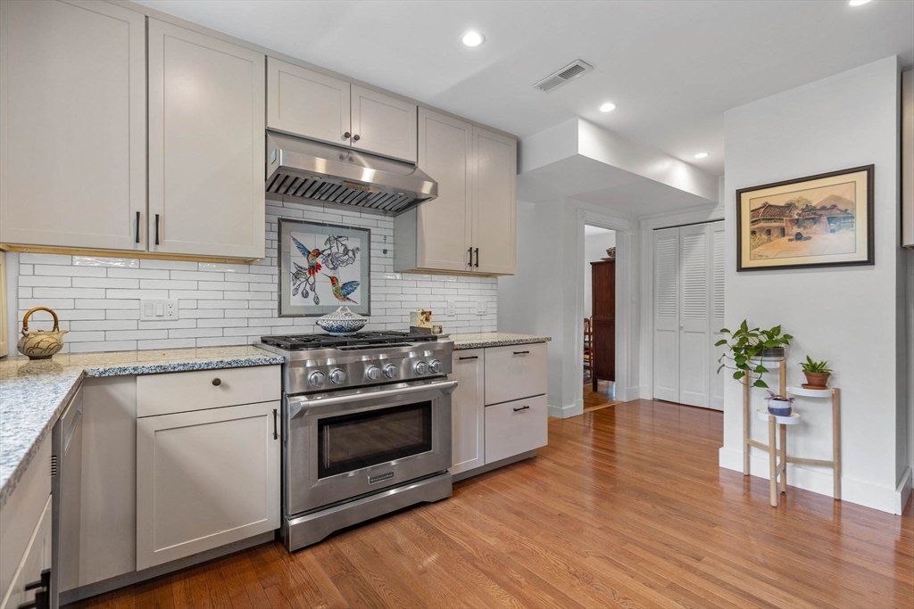 228 Langley Road Newton, MA 02459 - Photo 8 of 39 a kitchen with a stove and white cabinets