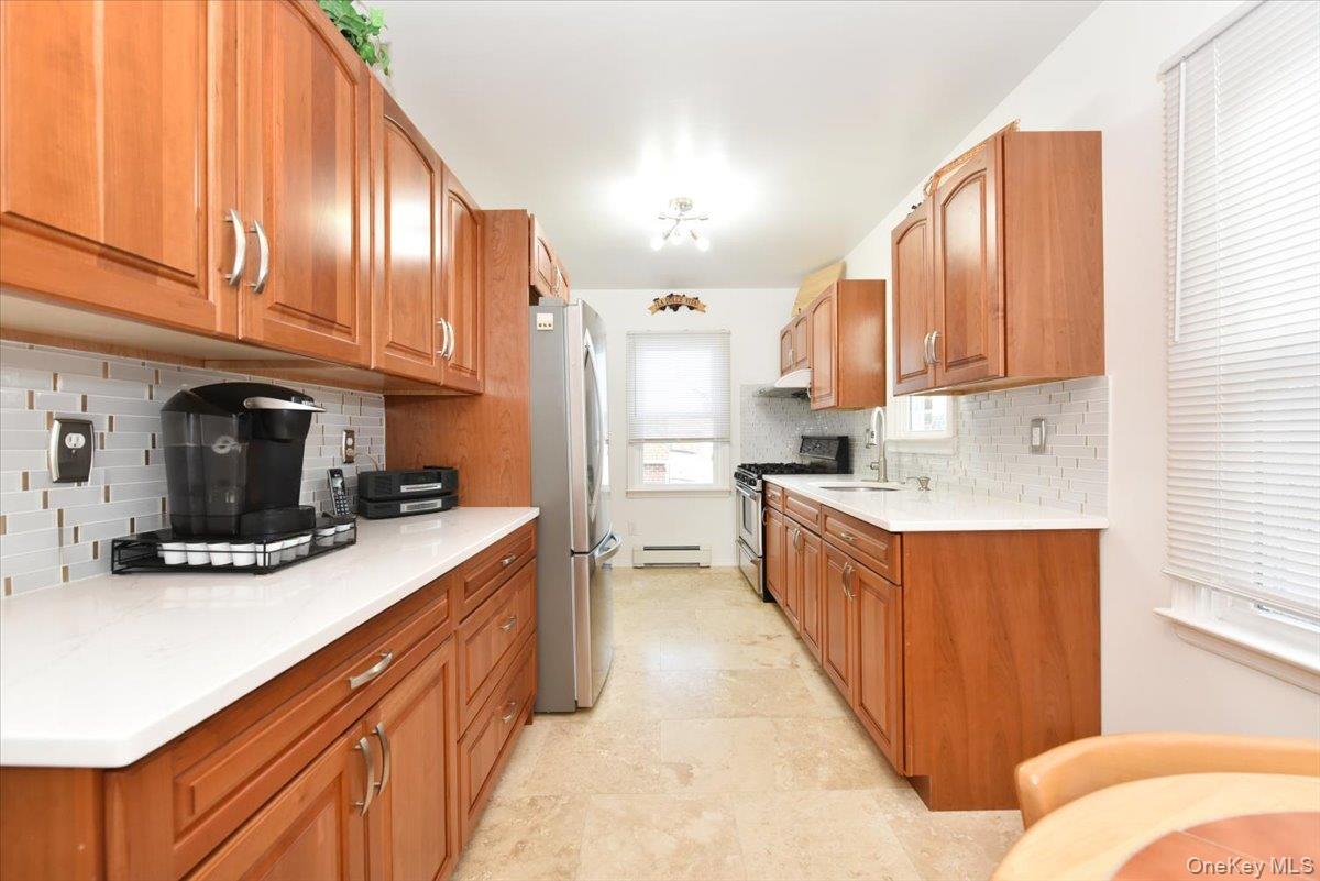 19 Sprague Drive Valley Stream, NY 11580 - Photo 15 of 30 a kitchen with stainless steel appliances granite countertop a sink a stove and a refrigerator