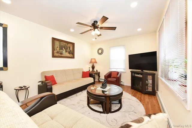 a living room with furniture a flat screen tv and a large window