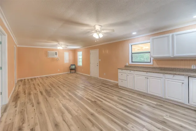 a view of empty room with window and ceiling fan