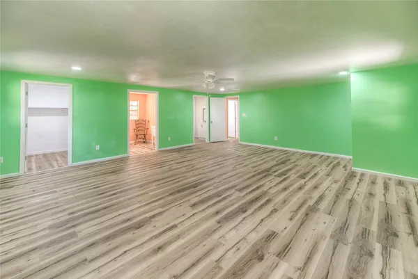 a view of an empty room with window and wooden floor