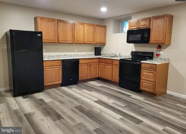 a kitchen with granite countertop a refrigerator and a stove top oven