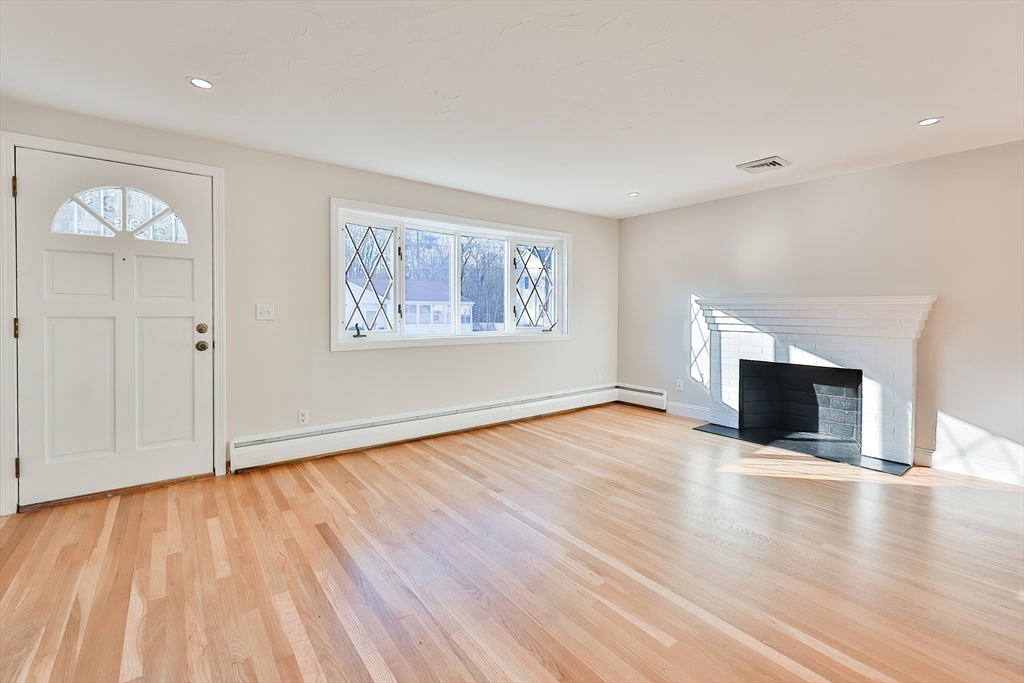 8 Dianthus Road Holbrook, MA 02343 - Photo 15 of 20 an empty room with wooden floor fireplace and windows