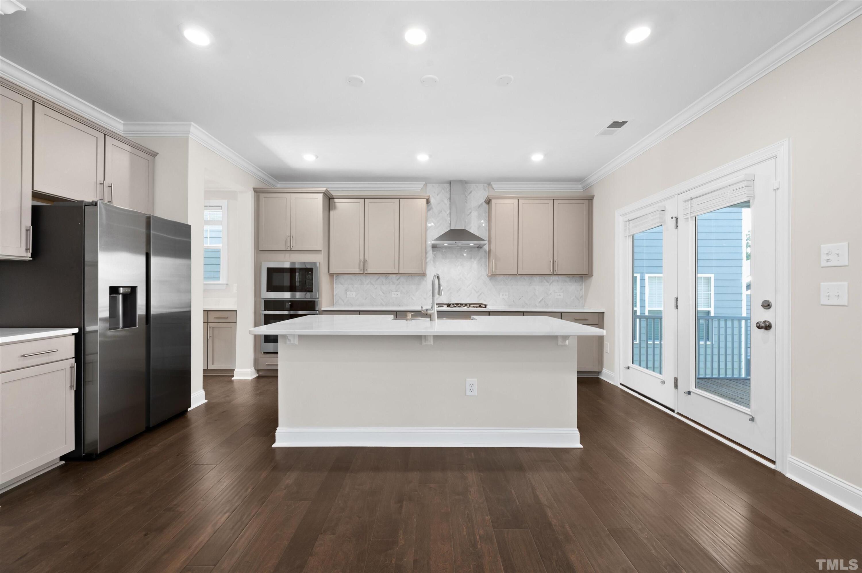 2917 Early Planting Avenue Apex, NC 27502 - Photo 11 of 41 a large kitchen with stainless steel appliances granite countertop a large center island a stove a refrigerator and a sink