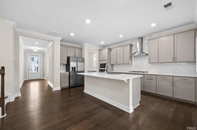 a kitchen with stainless steel appliances granite countertop a sink a stove and a refrigerator