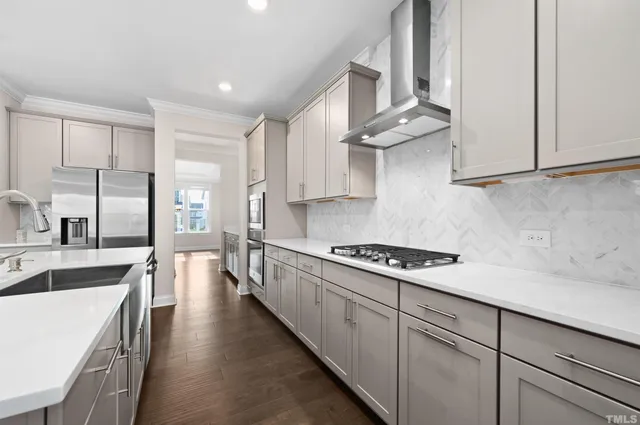 a kitchen with wooden floor and electronic appliances