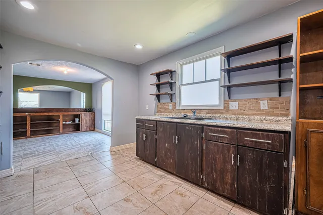 a large kitchen with kitchen island granite countertop a sink and cabinets