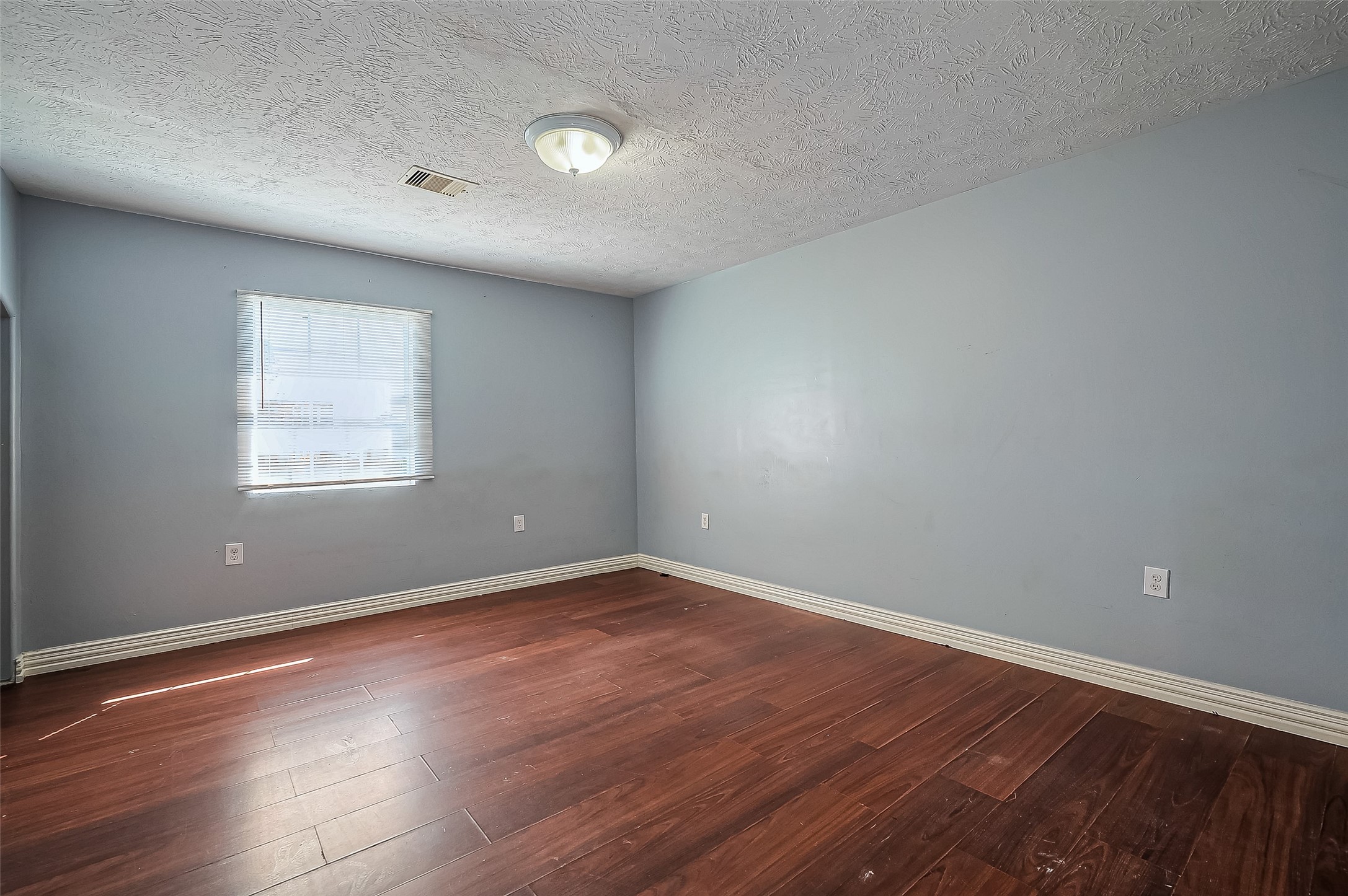710 East Sycamore Street Fresno, TX 77545 - Photo 18 of 32 a view of an empty room with wooden floor and a window