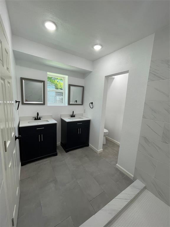 607 East Monterey Street Denison, TX 75021 - Photo 15 of 34 a large bathroom with a double vanity sink and mirror