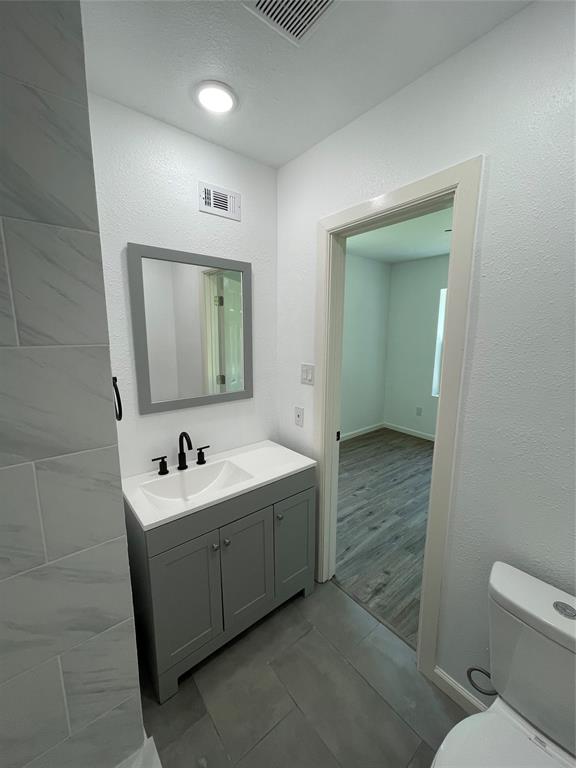 607 East Monterey Street Denison, TX 75021 - Photo 19 of 34 a bathroom with 2 sink toilet and mirror