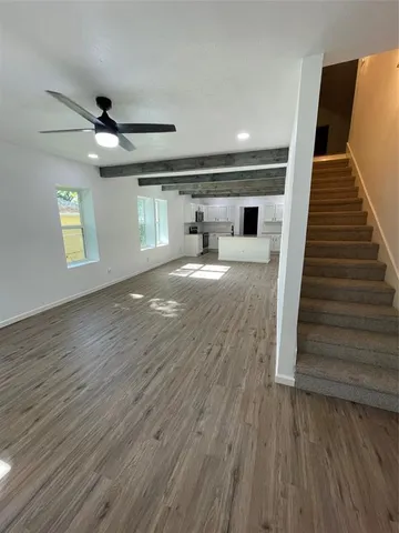 a view of a livingroom with wooden floor and staircase