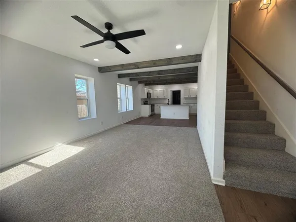a view of empty room with wooden floor and ceiling fan
