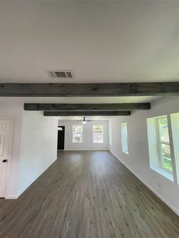 a view of a livingroom with wooden floor and a window