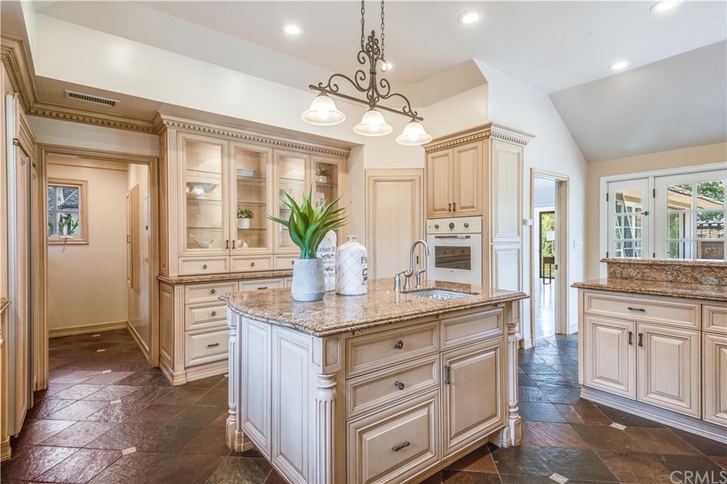 4255 Chestnut Avenue Long Beach, CA 90807 - Photo 11 of 48 a kitchen with kitchen island granite countertop a stove and white cabinets